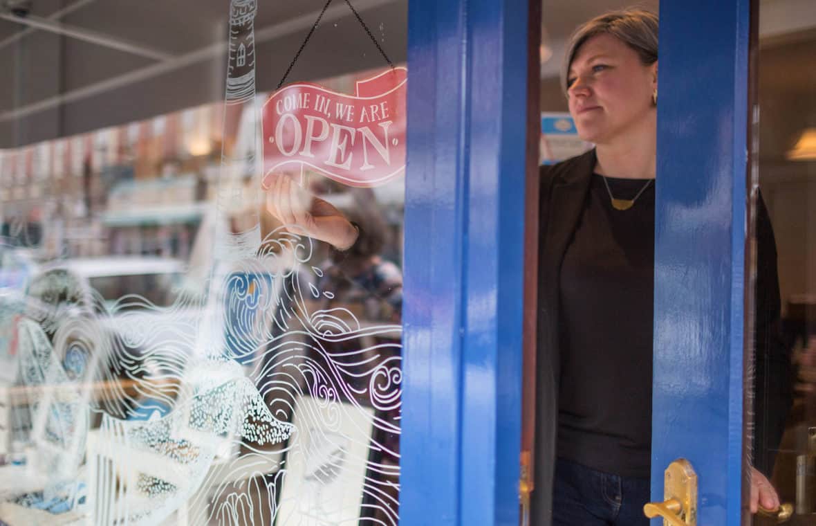 A business owner opening up her shop in Barry